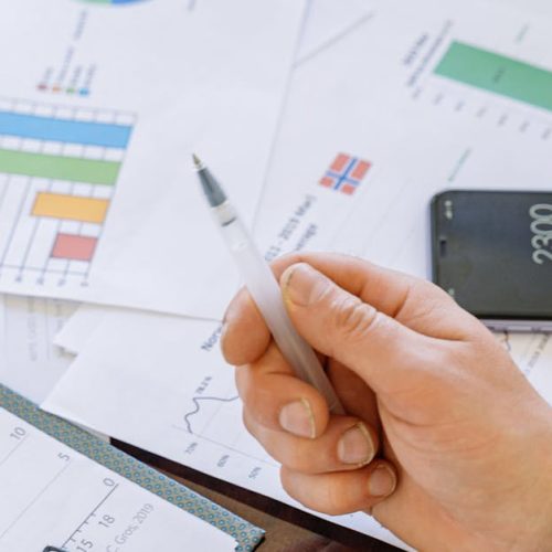 A close-up of businesspeople analyzing financial data and charts during a meeting.