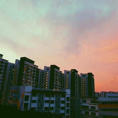 Beautiful high-rise buildings in Singapore under a vibrant sunset sky.